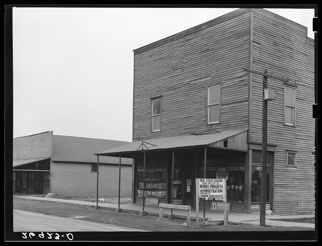 A storefront carries a Works Progress Administration sign about a new school building in Cambria, Illinois.
